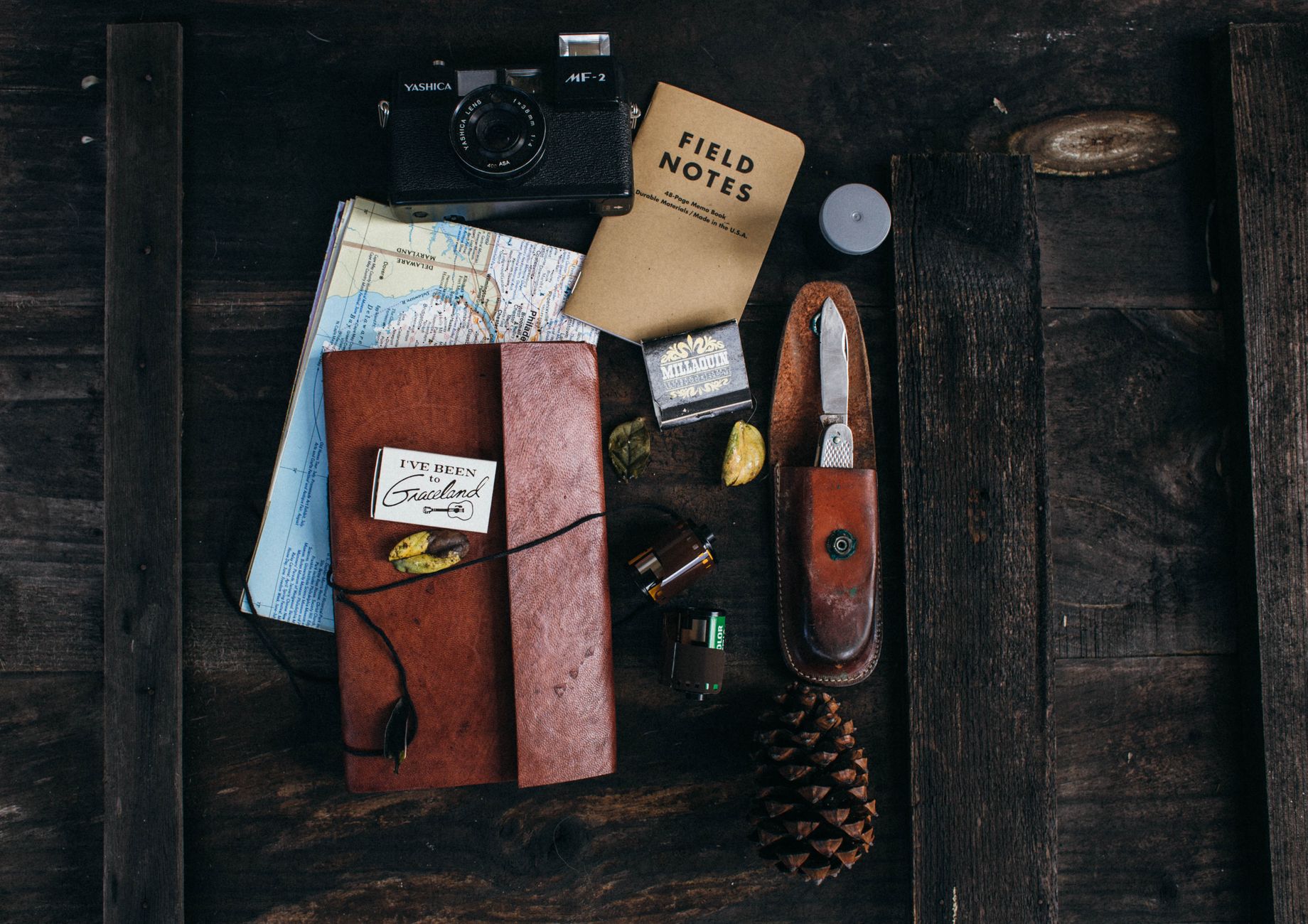 Notebook and camera on wooden rustic desk